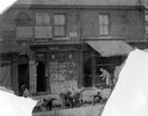 Nos.  557 and 559 Attercliffe Road, showing James Yeardley, shop manager, cleaning the shop and workmen digging a trench in front of the shop