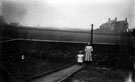 Young Gladys and Nellie Woodriff at the bottom of the garden path they shared with their neighbours, the Robinsons, No. 324 Bellhouse Road, Spring Cottages (right)