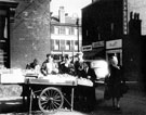 View: v01920 Fruit stall, Attercliffe Road with No. 648 Jn. W. Scott's, hairdressers; 650 John Shentall Ltd, grocer with Shirland Lane in the background