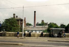 View: v02693 Bus shelter, Holme Lane showing the chimney of the Wire Works and the rear of the Midland Bank building, Langsett Road