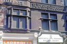 Carved detail, St. James Chambers and signs for Ladbrokes, betting shop and Newcastle upon Tyne Permanant Building Society, No. 56 Church Street