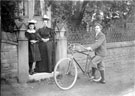 Lady and Girl at the gate with Man and Bicycle
