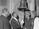 View: s28114 Former Captain A.W. Clarke hands over the Ships Bell of the Southampton Class Cruiser, HMS Sheffield to Lord Mayor Harold Lambert and the Very Rev. Ivan D. Neil, Provost of the Cathedral for safe keeping