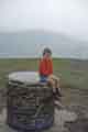Richard Teasdale, son of Bob Teasdale, sitting on the Trig point on top of Lose Hill with Win Hill in the background.