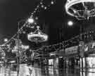 View: s30977 Christmas illuminations, Fargate showing 20 - 26 Proctors Ltd., house furnishers; Nos. 28 - 30 Lennards Ltd., shoe retailers and Nos. 34 - 36 Jackson the Tailor