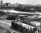 Troops of the 46th West Riding and North Midland Divisional Engineers constructing the first operational Bailey Bridge over the River Voltumo, Italy