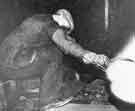 Billy Hart covers his face with gloved hand whilst he measures heavy armour plate with calipers whilst still red hot from the rolling mill Billy Hart covers his face with gloved hand whilst he measures heavy armour plate with calipers whilst still red hot from the rolling mill