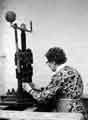 Woman working on a single ball fly press. Woman working on a single ball fly press.