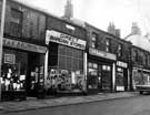 View: u06886 Netherthorpe Place: H. and K. Baldwin, ladies outfitters, Direct Bargain Stores, clothing, E. and Y. Anderson, furniture store and H. Savage, butchers