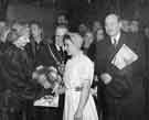 View: u10673 Buffer girl, Ethel Jones (nee Spotswood), from Walker and Hall Ltd., presenting flowers to Clement Atlee's wife (first left) at the City Hall showing Clement Attlee (first right) and the Lord Mayor, Alderman William Ernest Yorke (centre)