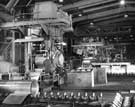 Thos. Firth and John Brown Ltd. - cold rolling continuous coils of brass strip in a 4-high mill, using forged steel work and back-up rolls.  3-stand tandem Mill in the background.