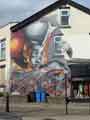 Foreground, mural by Trik 09 on gable end of house on Empire Road at junction with Abbeydale Road