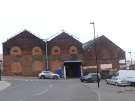 View from Forncett Street of entrance to Carwood Park factory units on Carwood Road showing (right) Express Tyres