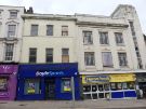 View: a07216 Shops on Haymarket showing (left) No. 17 Boyle Sports, bookmakers and (right) Nos. 19 - 21 Heron Foods, discount supermarket