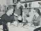 Batchelors Foods Ltd., Beatrice Pugh serves dinner to Paul Wragg and Mostyn Staniforth, both aged 16, apprentice electricians at the Sheffield factory at her home in New Chester Road, Port Sunlight, Cheshire