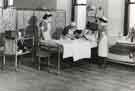 Sister demonstrating use of implements with male patient in bed, Clarke House School of Nursing, Clarke Drive Sister demonstrating use of implements with male patient in bed, Clarke House School of Nursing, Clarke Drive