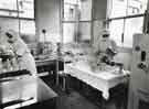 Nurses with mask measuring milk for feeding bottles at a Sheffield hospital Nurses with mask measuring milk for feeding bottles at a Sheffield hospital