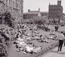 Sunbathing in the Peace Gardens looking towards Norfolk Street showing (left) the Town Hall