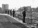 Men watching the construction of the Town Hall extension (known as the Egg Box (Eggbox)) from Cadman Lane showing (top left) Redvers House, c. 1977 Men watching the construction of the Town Hall extension (known as the Egg Box (Eggbox)) from Cadman Lane showing (top left) Redvers House, c. 1977
