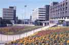 Flower beds in Charter Square roundabout showing (right) Telephone House and (centre) Milton House, offices