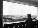 Gleadless Valley. A pensioner gazes from her flat in a thirteen storey point block across Hemsworth
